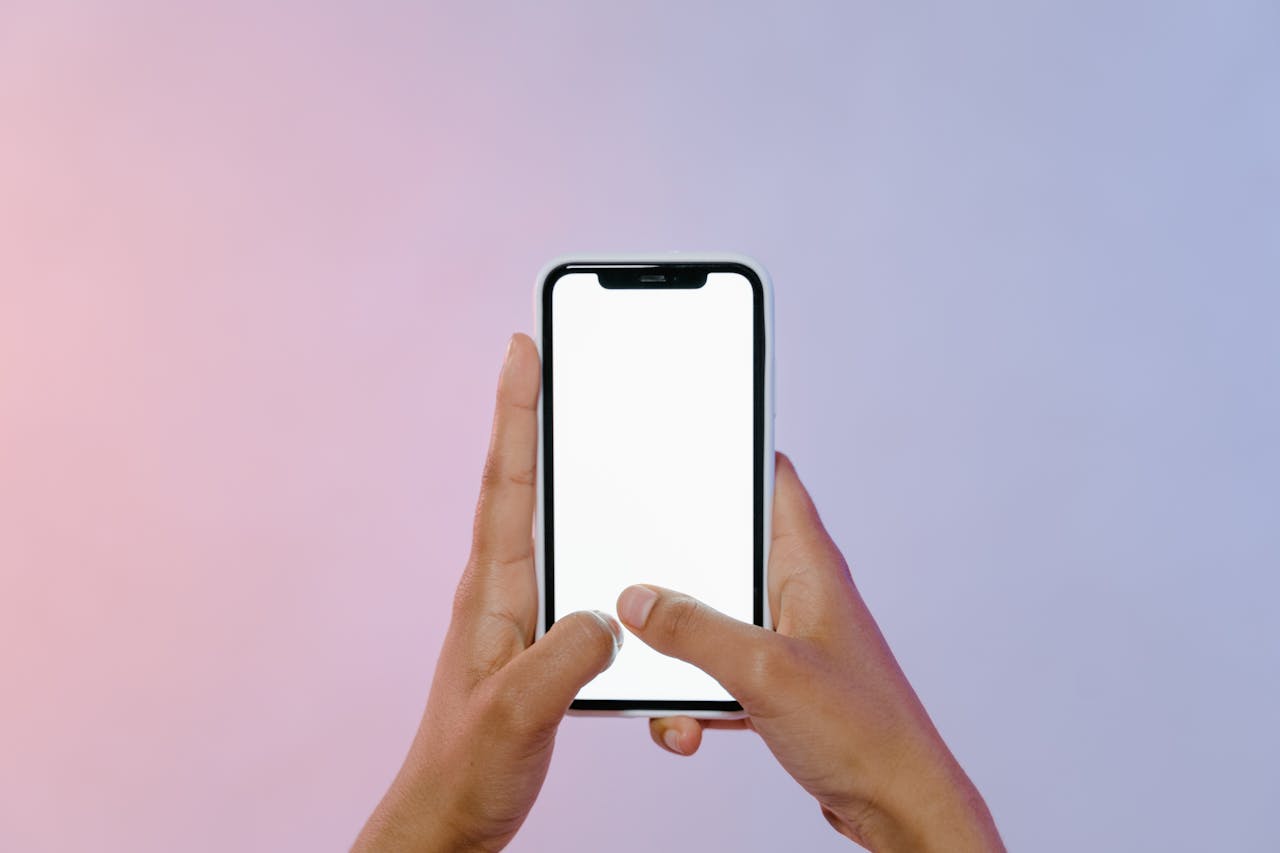 Close-up of hands holding a smartphone with a blank screen, ideal for mockups.